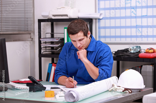 Photo: Manual worker completing paperwork Manual worker completing paperwork