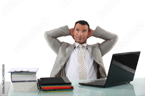 Photo: Office worker stretching at his desk Office worker stretching at his desk