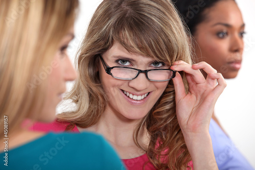 Photo: Young woman peering over her glasses Young woman peering over her glasses