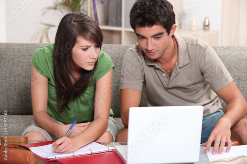Photo: Young couple using a laptop computer Young couple using a laptop computer