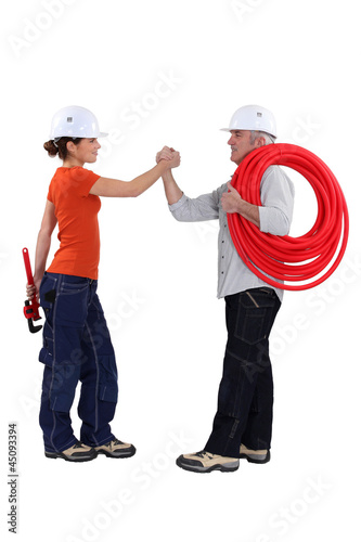 Photo: Two handyman shaking hand. Two handyman shaking hand.