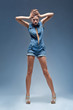 High fashion model in blue jeans overalls posing in studio