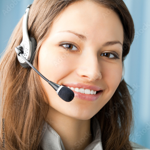 Photo: Cheerful smiling support phone operator at office Cheerful smiling support phone operator at office