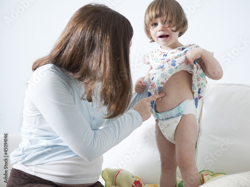 Photo: "USA, California, San Francisco, girl (2-3) with mother touching her belly" "USA, California, San Francisco, girl (2-3) with mother touching her belly"