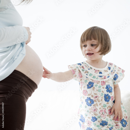 Photo: "USA, California, San Francisco, little girl (2-3) touching pregnant mother's belly" "USA, California, San Francisco, little girl (2-3) touching pregnant mother's belly"