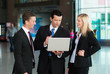 Redende Business-Gruppe mit Laptop