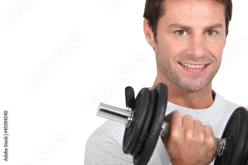 Photo: Closeup of smiling man with dumbbell Closeup of smiling man with dumbbell