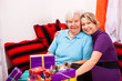 Foto: mutter und tochter sitzen auf couch mit vielen geschenken mutter und tochter sitzen auf couch mit vielen geschenken