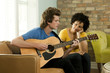 "USA, Utah, Provo, young man playing guitar and young woman listening him"