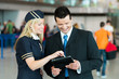 Freundliche Stewardess und Business-Mann analysieren etwas am Ta