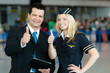 Business-Mann und Stewardess zeigen Daumen hoch