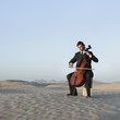 "USA, Utah, Little Sahara, young man with cello in desert"