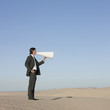 "USA, Utah, Little Sahara, businessman shouting through loud speaker in desert"