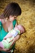 Happy young mother with sleeping child on hands