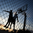 Photo: "USA, Utah, Salt Lake City, two young men playing street basketball, low angle view" "USA, Utah, Salt Lake City, two young men playing street basketball, low angle view"