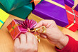 Foto: Seniorin sitzt und packt geschenke ein oder aus 3 Seniorin sitzt und packt geschenke ein oder aus 3