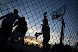 Photo: "USA, Utah, Salt Lake City, four young men playing street basketball, low angle view" "USA, Utah, Salt Lake City, four young men playing street basketball, low angle view"