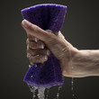 Photo: Young woman's hand squeezing wet sponge Young woman's hand squeezing wet sponge