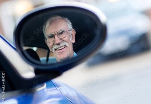 Photo: Senior man driving a car Senior man driving a car