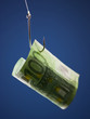 "One hundred Euros banknote on hook, against blue background"
