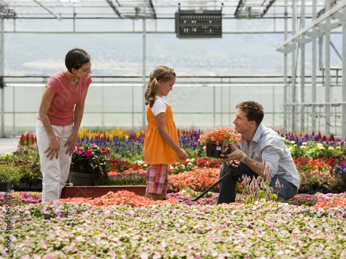 Photo: "USA, Utah, Salem, girl (8-9) with parents choosing plants in greenhouse" "USA, Utah, Salem, girl (8-9) with parents choosing plants in greenhouse"