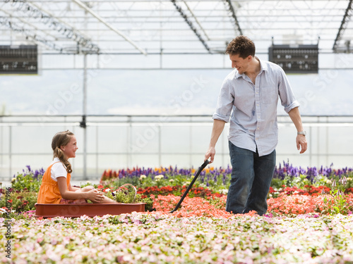 Photo: "USA, Utah, Salem, girl (8-9) with father in greenhouse" "USA, Utah, Salem, girl (8-9) with father in greenhouse"