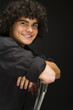 "Teenage boy (16-17) sitting backwards on chair, portrait"