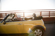 "USA, California, San Francisco, young couple sitting car with Golden Gate Bridge in background, portrait"