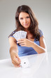 Woman playing cards with ace of spades in her hand