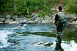 A fisherman fishing on a river