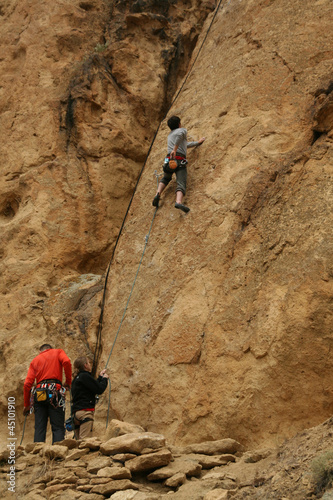 Photo: Woman belaying a climber on rock face Woman belaying a climber on rock face