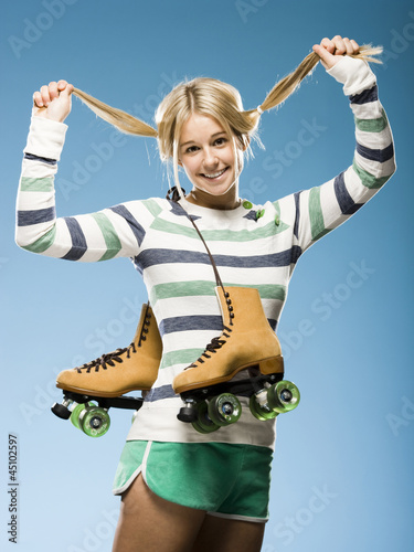 Photo: Studio portrait of young woman with roller skates Studio portrait of young woman with roller skates