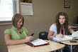Photo: "USA, Utah, Two teenage girls (14-17) working in classroom, one using mobile phone" "USA, Utah, Two teenage girls (14-17) working in classroom, one using mobile phone"