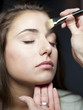 "USA, Utah, Orem, Young woman having make-up applied"