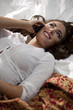 Photo: "USA, Utah, Orem, Young woman lying on bed talking on phone" "USA, Utah, Orem, Young woman lying on bed talking on phone"