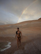"USA, Utah, Lake Powell, Young woman wearing bikini and walking, rainbow in the background"