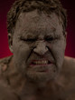 Angry young man covered in mud
