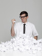 Studio portrait of young man behind stack of paper balls