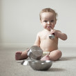 "USA, Utah, Orem, Shirtless baby (6-11 months) playing with cooking utensils"