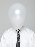 Photo: Studio portrait of young man wearing shirt and tie with face covered by white balloon Studio portrait of young man wearing shirt and tie with face covered by white balloon