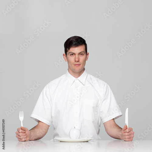 Photo: Studio portrait of young man waiting for meal Studio portrait of young man waiting for meal