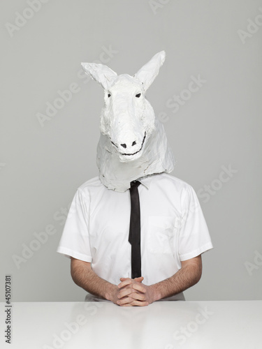 Photo: Studio portrait of young man wearing horse mask Studio portrait of young man wearing horse mask