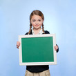 Studio portrait of girl (10-11) holding blank green chalkboard