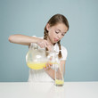 Studio shot of girl (10-11) pouring lemonade