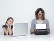 Studio shot of mother using typewriter and daughter (10-11) looking at laptop