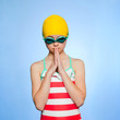 "Studio shot of girl (10-11) wearing swimsuit, swimming cap and swimming goggles"