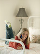 Photo: "USA, Utah, Cedar Hills, Teenage girl (14-15) lying on bed, talking on mobile phone" "USA, Utah, Cedar Hills, Teenage girl (14-15) lying on bed, talking on mobile phone"