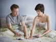 couple playing cards in bed