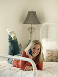 Photo: "USA, Utah, Cedar Hills, Teenage girl (14-15) lying on bed, talking on mobile phone" "USA, Utah, Cedar Hills, Teenage girl (14-15) lying on bed, talking on mobile phone"
