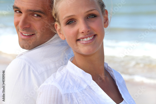 Photo: Couple back to back on the beach Couple back to back on the beach